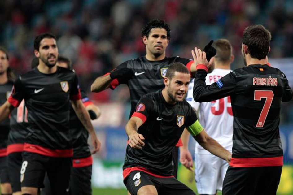 Jugadores del Atlético de Madrid Adrián López (d) y Mario Suárez (c) celebran el gol marcado por su compañero Raúl García (i) ante el Hapoel Tel Aviv / EFE