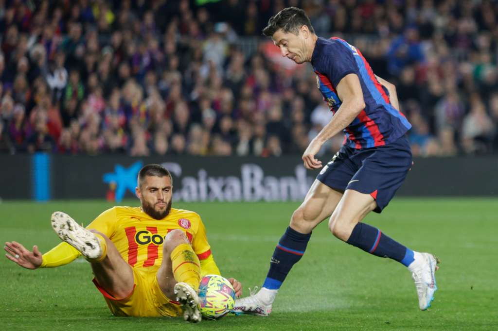 BARCELONA, 10/04/2023.- El delantero polaco del FC Barcelona Robert Lewandowski (d) lucha con el defensa del Girona FC David López Silva (i) durante el partido de fútbol de la jornada 28 de LaLiga que FC Barcelona y Girona FC juegan este lunes en el Camp Nou. EFE/ Quique García