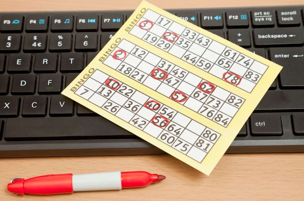 Un cartón de bingo sobre el teclado de un computador