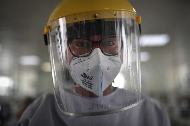 La cara de una doctora con tapabocas y una máscara de protección