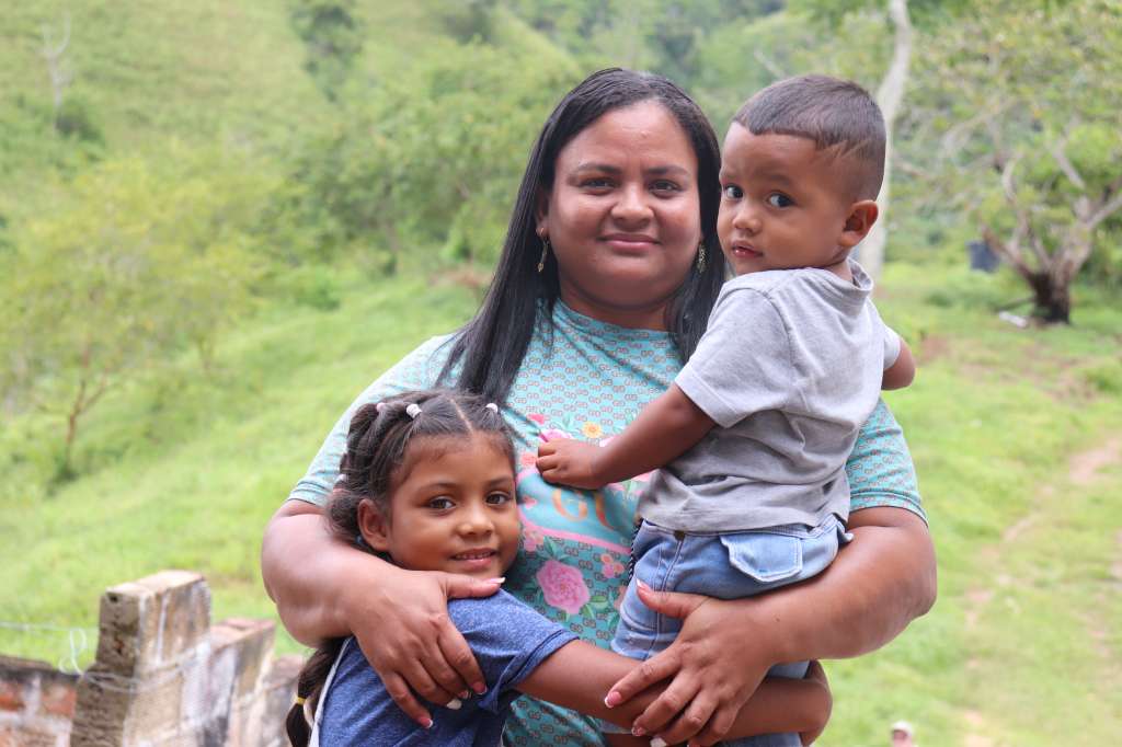 Patricia abraza a dos de sus hijos en el Espacio Territorial de Capacitación y Reincorporación El Viento, en Yalí, Antioquia.