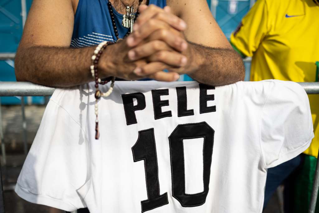 AME3840. SANTOS (BRASIL), 02/01/2023.- Seguidores del fallecido ex jugador Pelé llegan al amanecer para asegurar un lugar en la fila frente al estadio Vila Belmiro, para darle el último adiós durante un velorio hoy, en la ciudad de Santos (Brasil). Varios aficionados al fútbol brasileños pasaron la noche guardando fila para acudir este lunes al velatorio de Pelé, fallecido el pasado jueves a los 82 años. EFE/ Isaac Fontana
