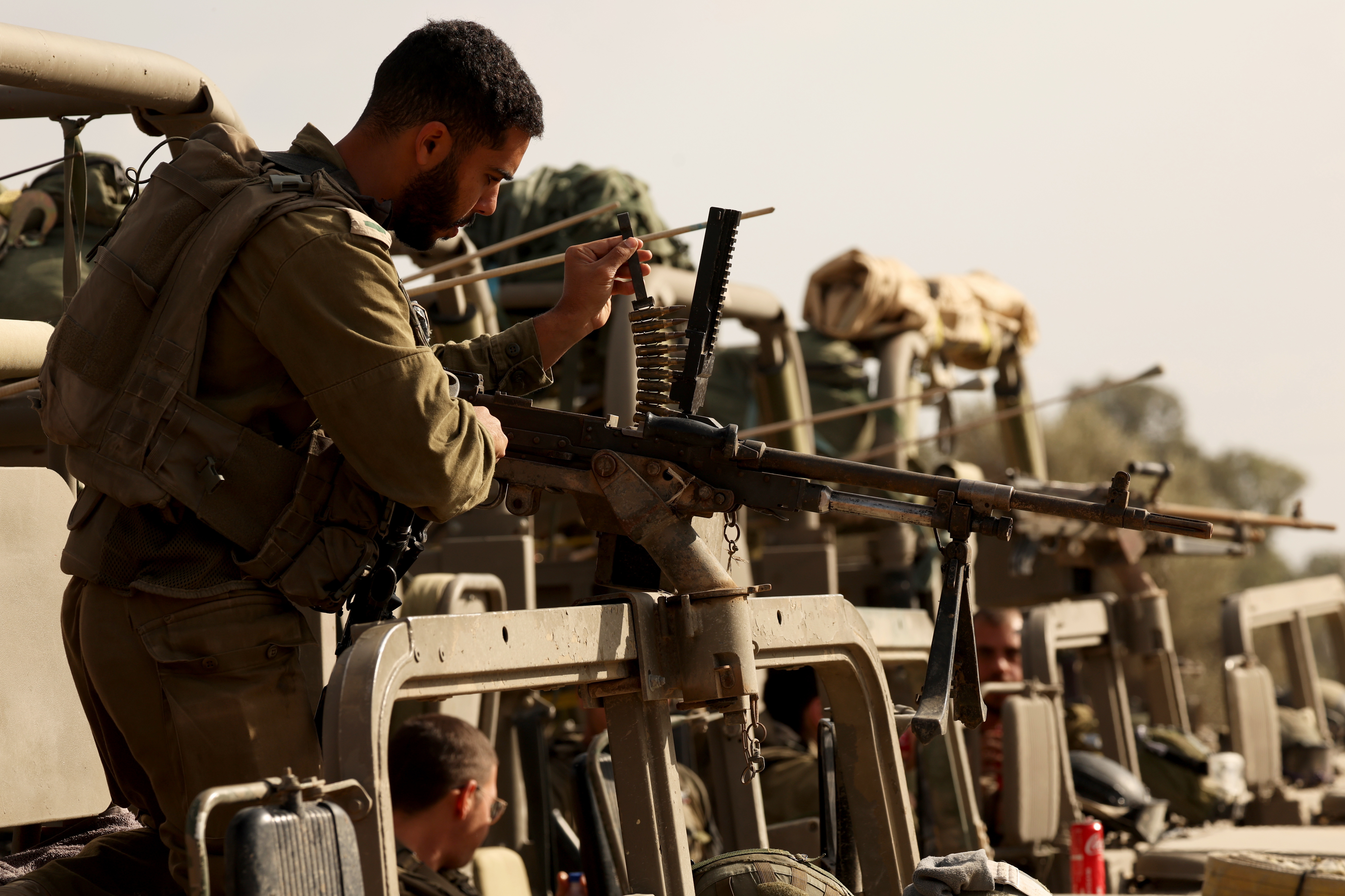 Lugar desconocido (Israel), 21/11/2023.- Un soldado israelí realiza trabajos de mantenimiento de su arma en un punto de reunión a lo largo de la frontera con Gaza, este martes tras regresar de la Franja de Gaza. Como parte de las "operaciones terrestres" de Israel en la Franja de Gaza, aviones militares israelíes atacaron aproximadamente 250 objetivos de Hamás durante el último día, anunció el ejército israelí el 21 de noviembre.EFE/ATEF SAFADI