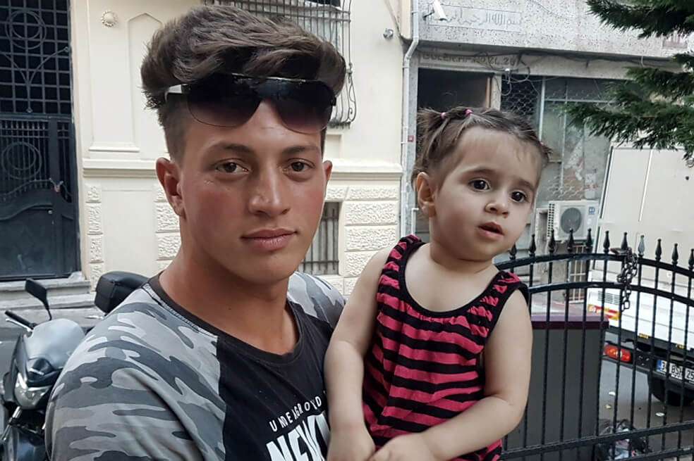  Faouzi Zabaat, un argelino de 17 años, posa con la pequeña Doha Mohammed. / AFP
