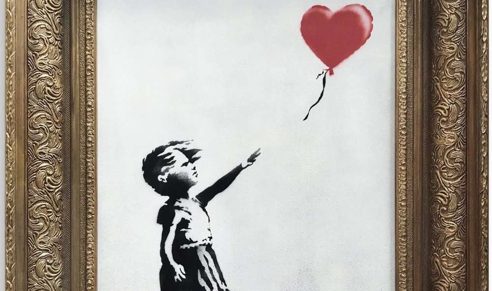La obra "Niña con globo", en acrílico y aerosol, ahora una de las más famosas de Banksy, muestra a una niña que deja partir al aire su globo rojo en forma de corazón. / Cortesía
