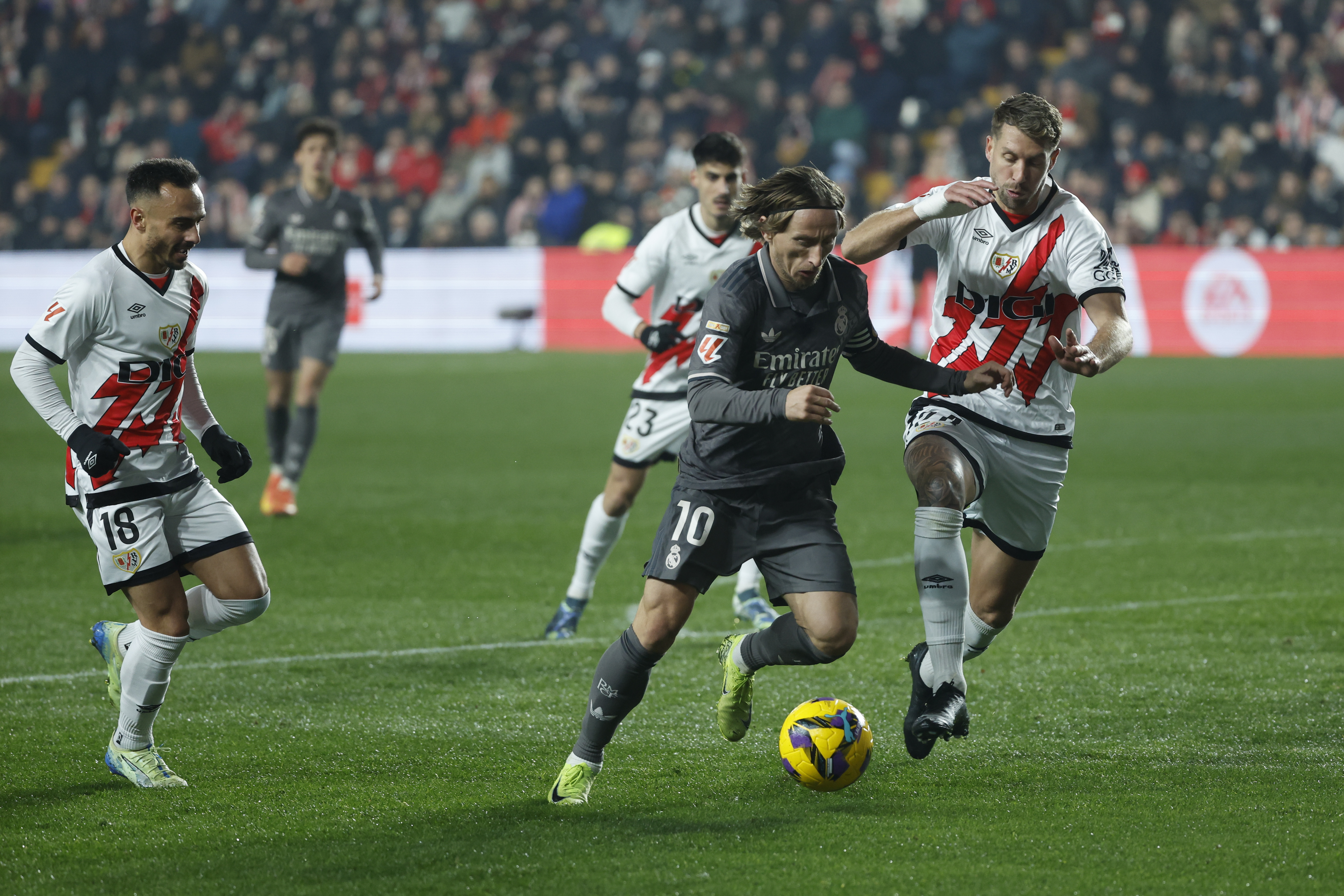 MADRID, 14/12/2024.- El centrocampista croata del Real Madrid, Luka Modric (c), controla el balón el defensa francés del Rayo Vallecano, Florian Lejeune, durante el encuentro correspondiente a la jornada 17 de Laliga EA Sports que disputan hoy sábado Rayo Vallecano y Real Madrid en el estadio de Vallecas, en Madrid. EFE / Juanjo Martín.