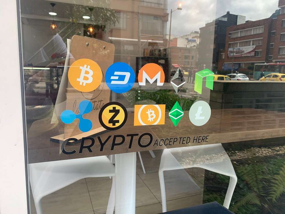 En la capital anuncios como estos identifican a los comercios que reciben criptomonedas como medios de pago.Diego OjedaDatos de la página de capitalización de mercado de criptomonedas, Coinmarketcap, dan cuenta de que la cotización más alta del Bitcoin fue el 17 de diciembre de 2017, cuando llegó a los US$20.000 (casi $68 millones). No obstante —y aquí el porqué la Superfinanciera la considera volátil—, se han registrado días en los que su precio cae drásticamente, como el 05 de julio de 2013, cuando tocó su punto más bajo: US$65,5 ($222.000).