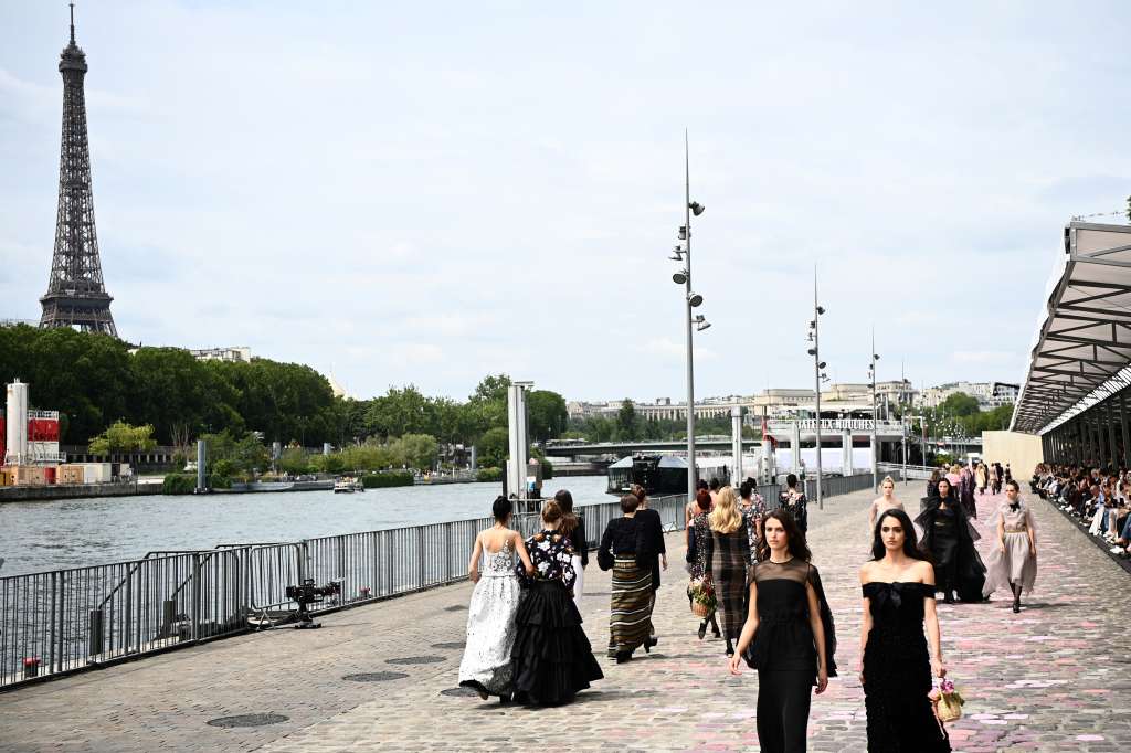 Con los adoquines pintados en varios tonos de rosa, y la Torre Eiffel al fondo, las modelos fueron desfilando a lo largo de un muelle. / AFP