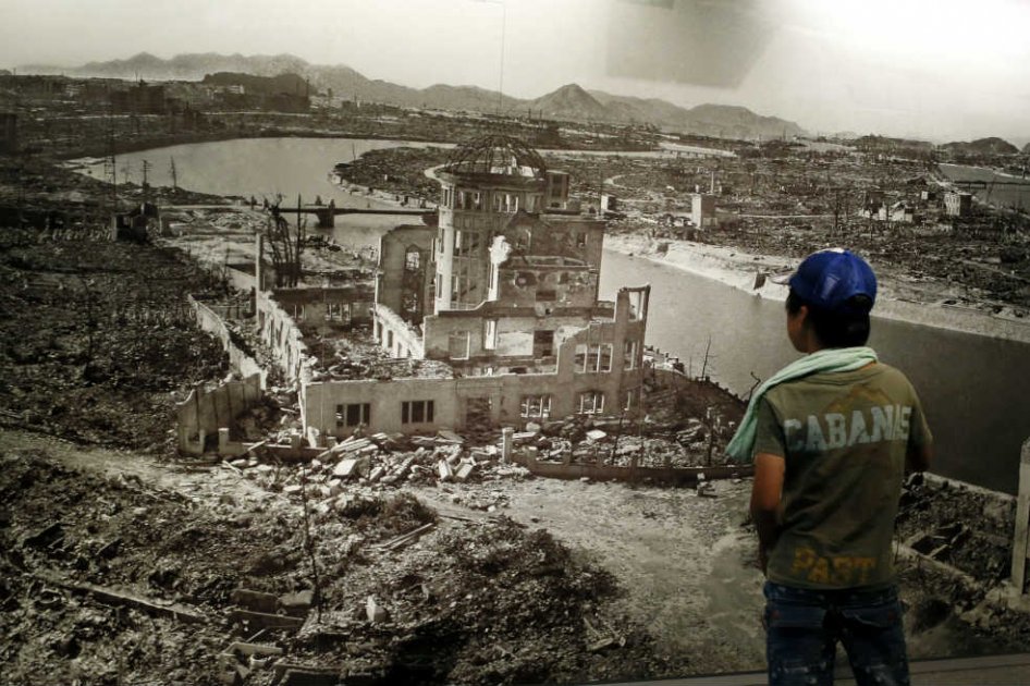 Un joven observa una gran fotografía de la ciudad de Hiroshima, oeste de Japón, devastada por una bomba nuclear en 1945.  / EFE