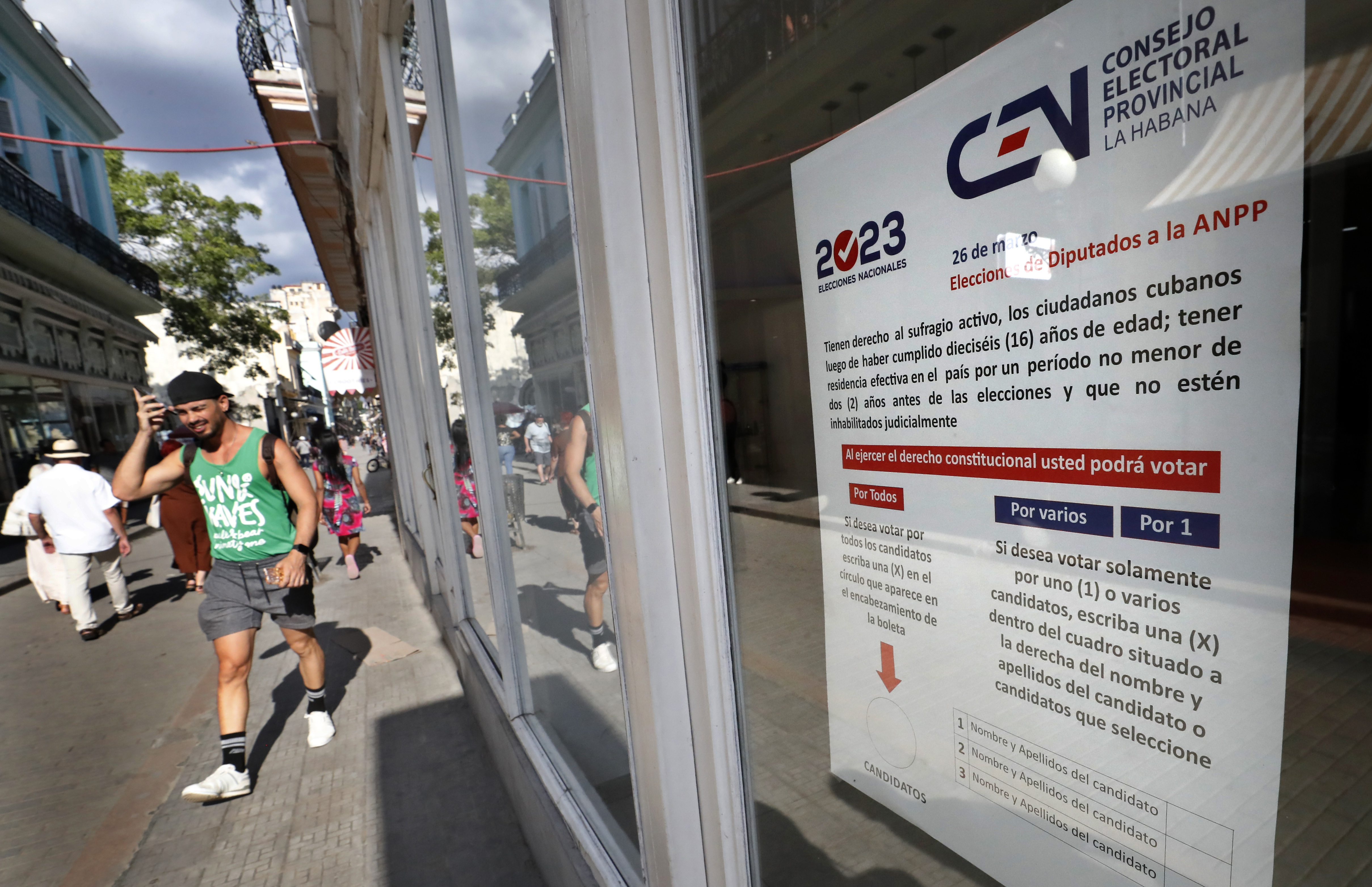 HAB01 LA HABANA (CUBA).- Personas caminan hoy frente a unos carteles informativos sobre el proceso electoral del domingo, en una calle de La Habana (Cuba). El Consejo Electoral Nacional (CEN) de Cuba declaró "listo" al país para las elecciones de los diputados al Parlamento mañana 26 de marzo, a las que están convocados a las urnas 8,1 millones de ciudadanos con derecho al voto. EFE/Ernesto Mastrascusa