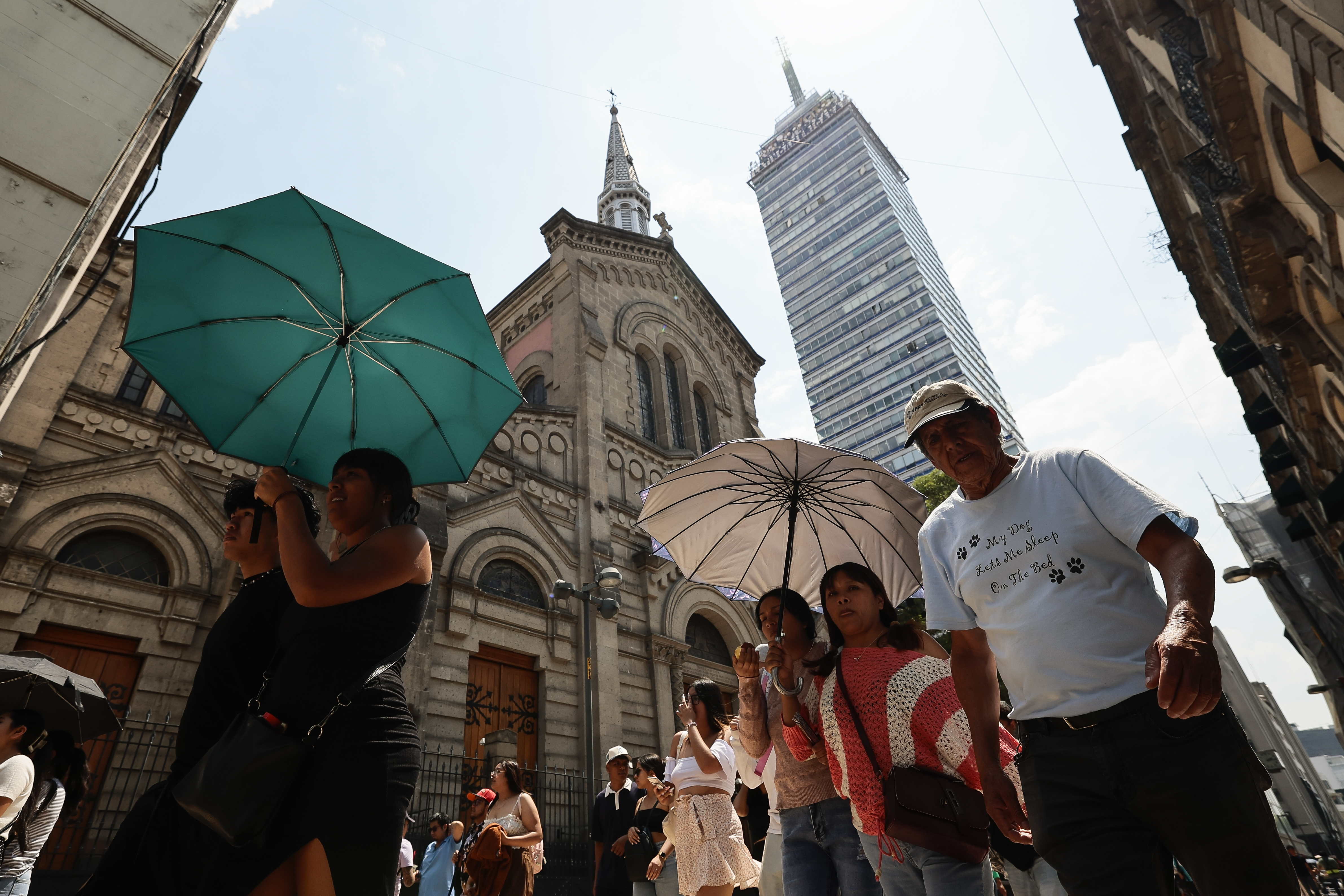 MEX8867. CIUDAD DE MÉXICO (MÉXICO), 24/05/2024.- Varias personas caminan con sombrilla para protegerse del sol, este viernes en Ciudad de México (México). La tercera ola de calor del año en México traerá este viernes temperaturas por encima de los 45 grados en casi la mitad de los estados del país, 15 de 32, aunque también habrá lluvias "muy fuertes", según informó el Servicio Meteorológico Nacional (SMN). EFE/José Méndez