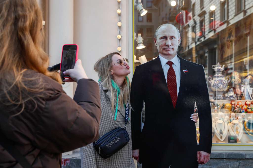 Moscow (Russian Federation), 13/03/2024.- A woman poses for photos next to a cardboard cutout of Russian president and presidential candidate Vladimir Putin on the street in Moscow, Russia, 13 March 2024. The Russian presidential elections will be held from 15 to 17 March 2024. (Elecciones, Rusia, Moscú) EFE/EPA/YURI KOCHETKOV
