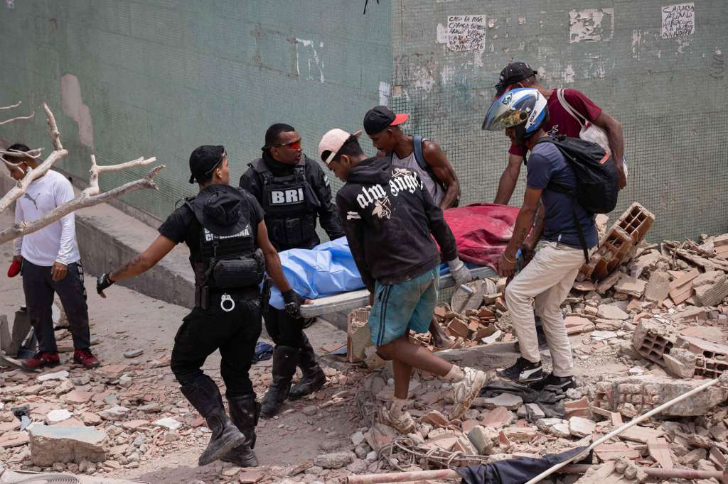AME4367. LA GUAIRA (VENEZUELA), 25/06/2026.- Voluntarios rescatan una víctima mortal este jueves, entre los escombros de edificios afectados por los terremotos en La Guaira (Venezuela). El número de fallecidos en Venezuela a causa de los dos terremotos del miércoles se elevó a 188 y el de heridos a 1.520, mientras que al menos 346 construcciones, entre edificios, hospitales y centros comerciales, resultaron afectadas, informó el presidente de la Asamblea Nacional (AN, Parlamento), el chavista Jorge Rodríguez. EFE/ Ronald Peña R.