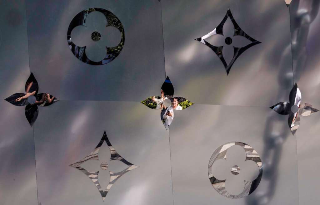 Shanghai (China), 07/07/2025.- People are reflected in the ornaments of the Louis Vuitton store shaped like a cruise ship, in Shanghai, China, 07 July 2025. Luxury retail group Louis Vuitton has launched an installation called The Louis at Taikoo Hui in Shanghai's Nanjing West Road business district. Standing nearly 100 feet tall, this ship-inspired structure pays tribute to the brand’s 19th-century heritage with a cabin made from classic Louis Vuitton cases and a hull adorned with the monogram. EFE/EPA/ALEX PLAVEVSKI
