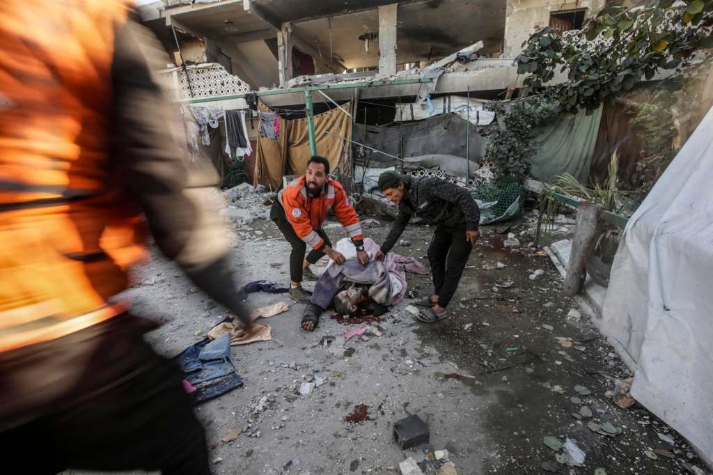 Gaza City (-), 25/04/2025.- GRAPHIC CONTENT - Palestinians inspect the body of a man following an Israeli airstrike, at Al Farabi school in Gaza City, northern Gaza Strip, 25 April 2025. According to the Palestinian Ministry of Health in Gaza, at least three Palestinians were killed and 10 others wounded in Israeli airstrikes. EFE/EPA/MOHAMMED SABER -- ATTENTION EDITORS: GRAPHIC CONTENT