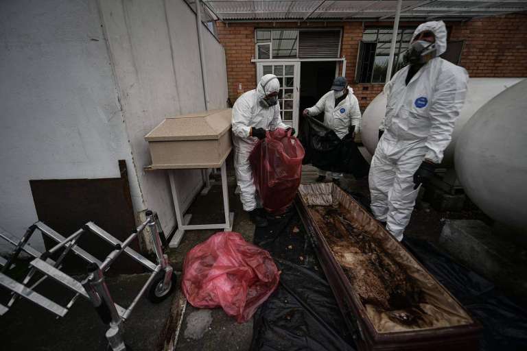 Tres hombres limpiando el interior de un ataúd