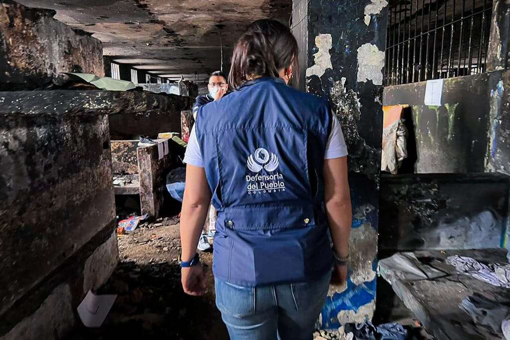 Funcionarios de la Defensoría del Pueblo observan la destrucción que dejó un incendio en la cárcel de Tuluá. Todo se ve reducido a cenizas.