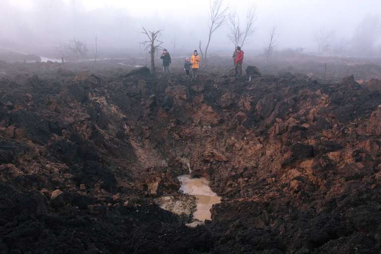 Kharkiv (Ucrania), 09/03/2023.- Los lugareños se reúnen alrededor de un cráter de bombardeo después de que un cohete impactara en el barrio de Pisochyn en las afueras de Kharkiv, Ucrania, este jueves. El Ministerio de Defensa del país confirmó que 34 misiles de crucero fueron derribados. Según el operador nuclear ucraniano Energoatom, la planta de energía nuclear (NPP) de Zaporizhzhia perdió energía como resultado de los ataques con misiles y estaba funcionando con generadores diesel.EFE/PAVLO PAKHOMENKO