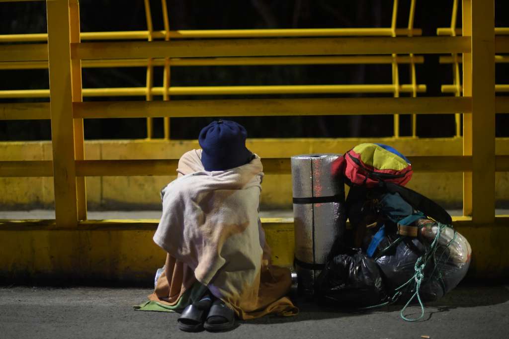 Familias de migrantes venezolanos esperan en el puente Rumichaca, frontera entre Colombia y Ecuador, la reapertura de este punto fronterizo hacia la población ecuatoriana de Tulcán.
