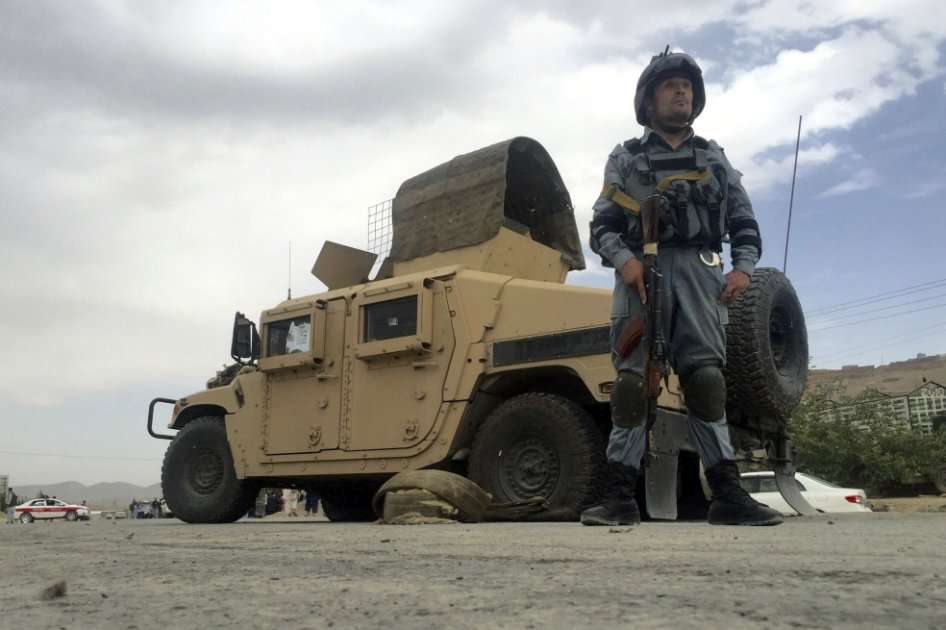 Un policía afgano asegura la zona tras el ataque suicida perpetrado contra un autobús de la policía a las afueras de Kabul (Afganistán). / EFE