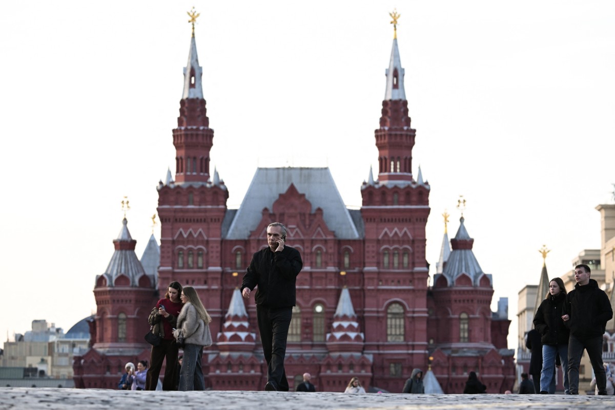 People, some using smartphones, walk across Red Square in central Moscow on March 17, 2026.