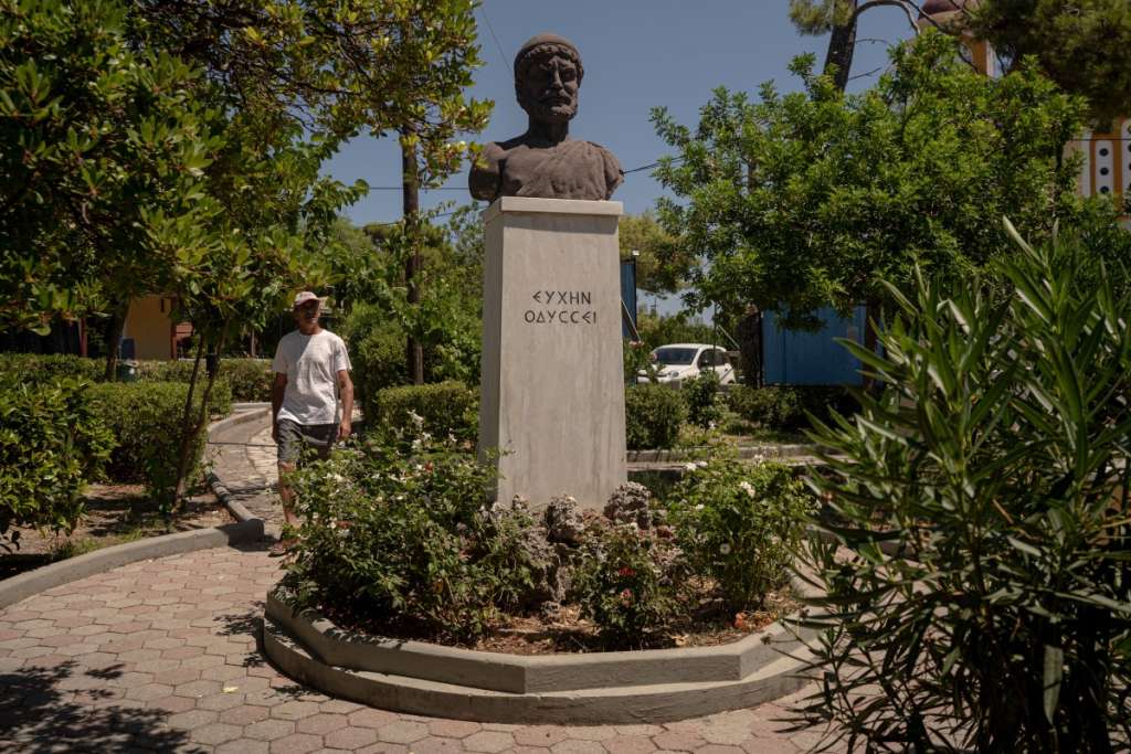 A man walks next to a bust of Odysseus in the central square of the village of Stavros, on the island of Ithaca, in the Ionian Sea, on August 3, 2026.