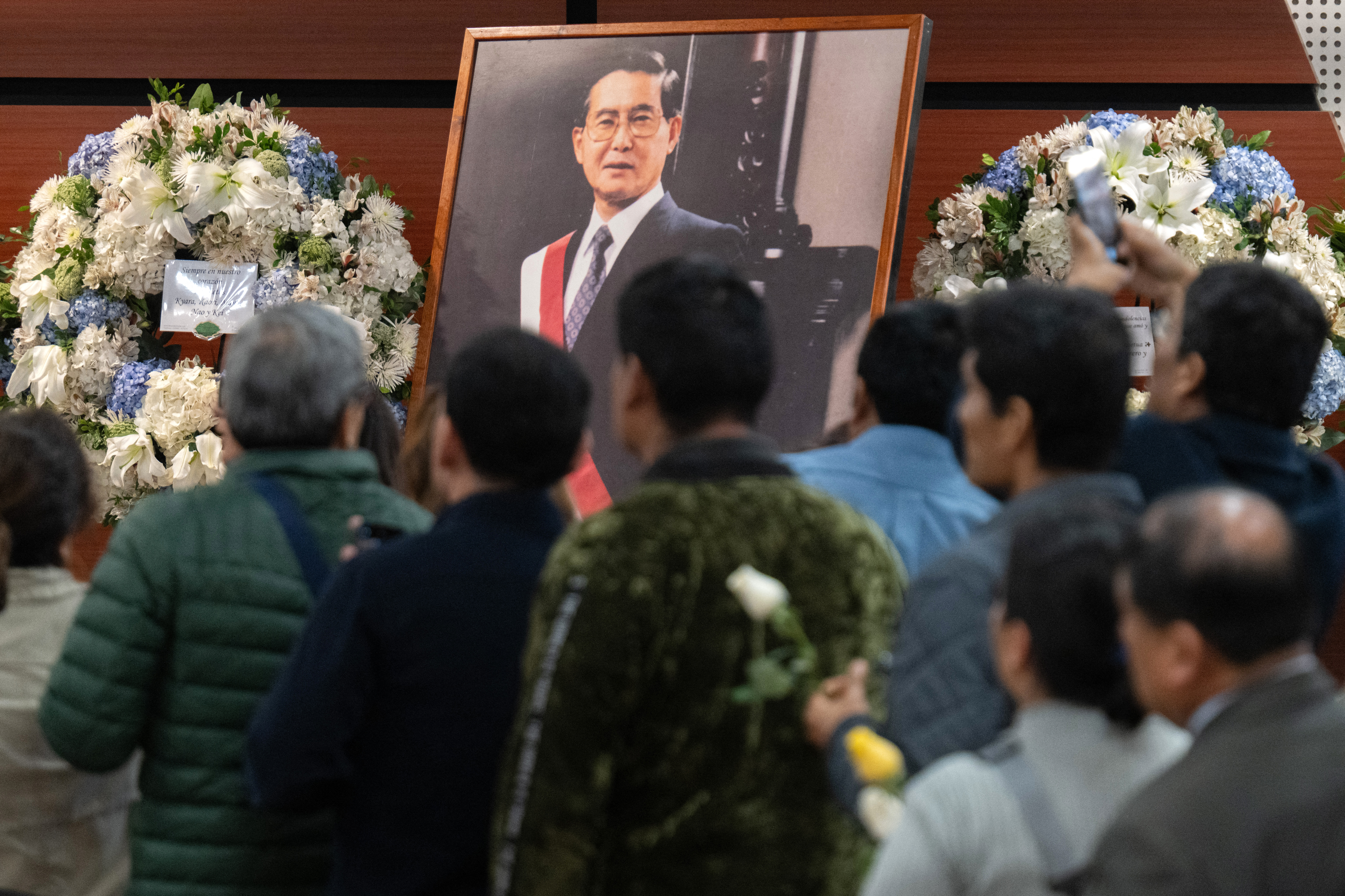 Supporters of the late former Peruvian President Alberto Fujimori (1990-2000) wait to enter the Culture Ministry during his state funeral in Lima on September 13, 2024.