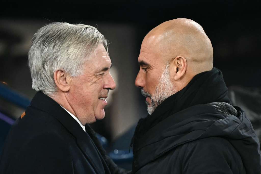 El entrenador italiano del Real Madrid, Carlo Ancelotti (izq.), y el entrenador español del Manchester City, Pep Guardiola (der.), se ríen juntos antes del partido de fútbol de la UEFA Champions League entre el Manchester City y el Real Madrid en el Etihad Stadium en Manchester, noroeste de Inglaterra, el 11 de febrero de 2025.