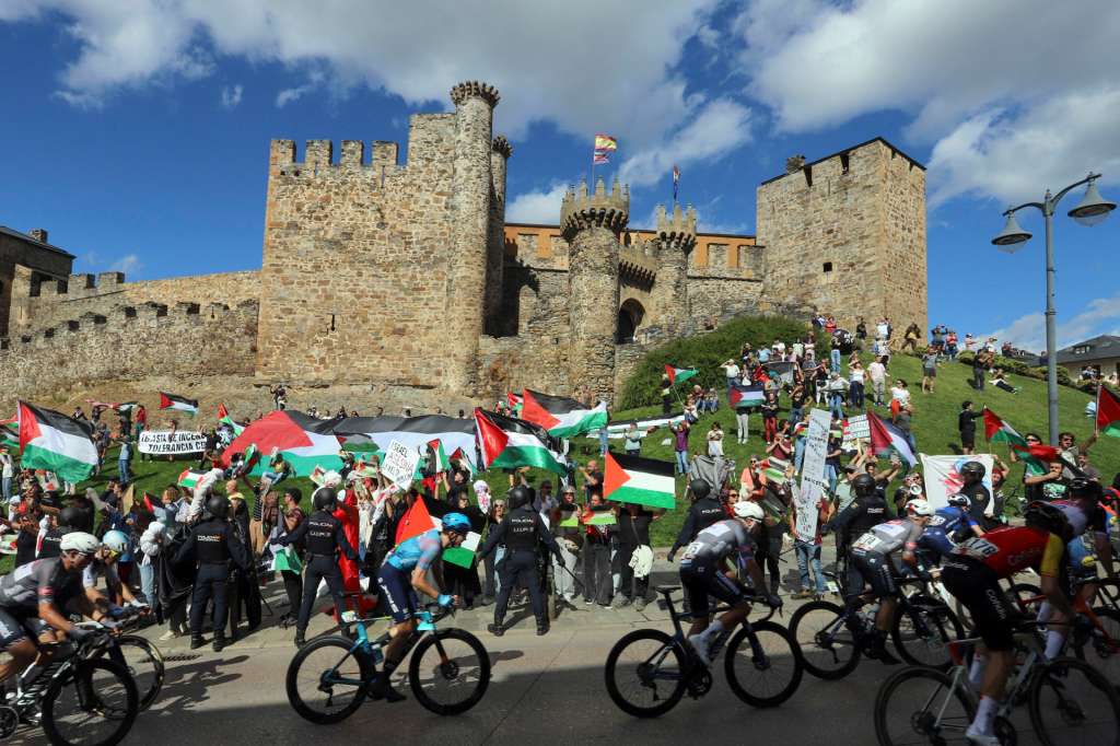 GRAF1079. PONFERRADA (LEÓN), 10/09/2025.- Decenas de personas protestan contra Israel al paso del pelotón por el Castillo de los Templarios en Ponferrada (León), durante la etapa 17 de la Vuelta Ciclista a España, disputada este miércoles entre O Barco de Valdeorras (Ourense) y Alto de El Morredero (EL Bierzo-León) y con 143,2km de recorrido. EFE/ Ana F Barredo