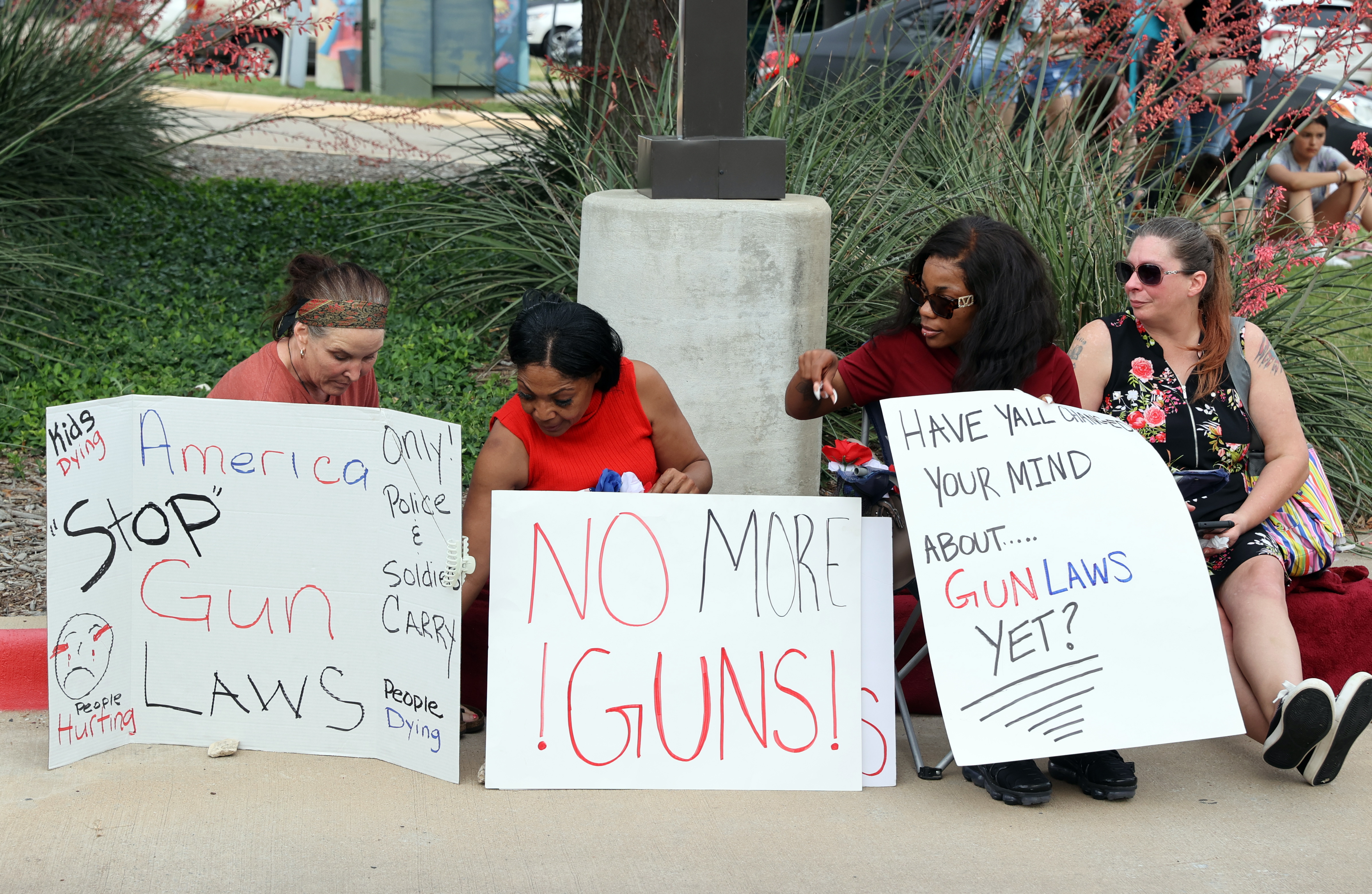 Allen (United States), 07/05/2023.- Women hold up signs about guns during a vigil in remembrance of those that were killed during the mass shooting at the Allen Premium Outlets Mall, in front of the Allen Premium Outlets in Allen, Texas, USA, 07 May 2023. Nine people including the gunman were killed on 06 May 2023. (Estados Unidos) EFE/EPA/ADAM DAVIS