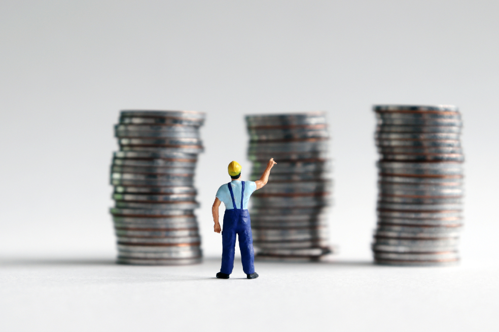 Ilustración que muestra a un trabajador frente a una pila de monedas.