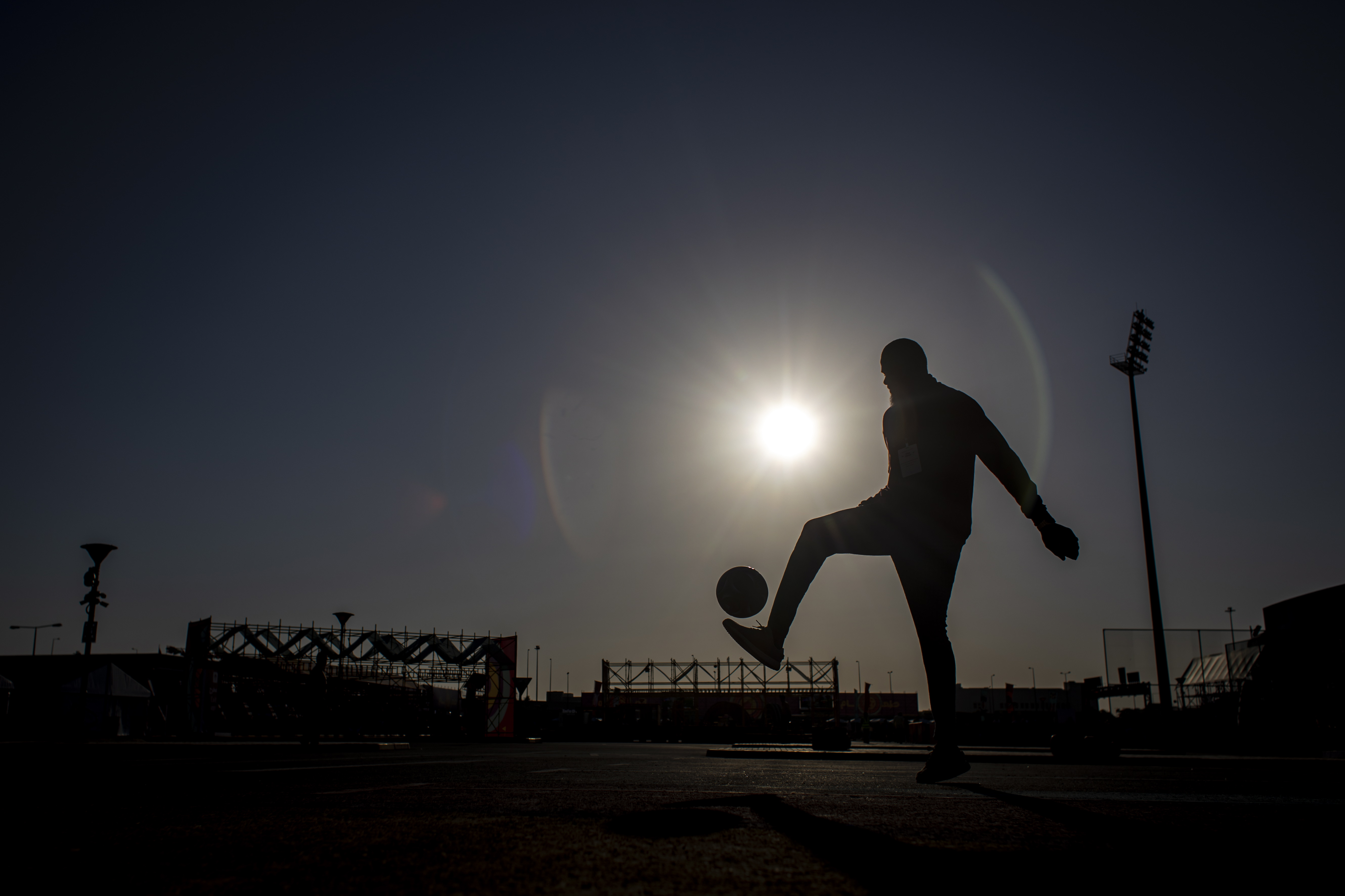 -FOTODELDIA- DOHA (CATAR), 25/11/2022.- Un hombre golpea el balón mientras algunos aficionados se congregan para ver el partido del Mundial de Qatar 2022 entre Catar y Senegal este viernes, en el estadio Asian Town Cricket de Doha, Catar. EFE/MARTIN DIVISEK