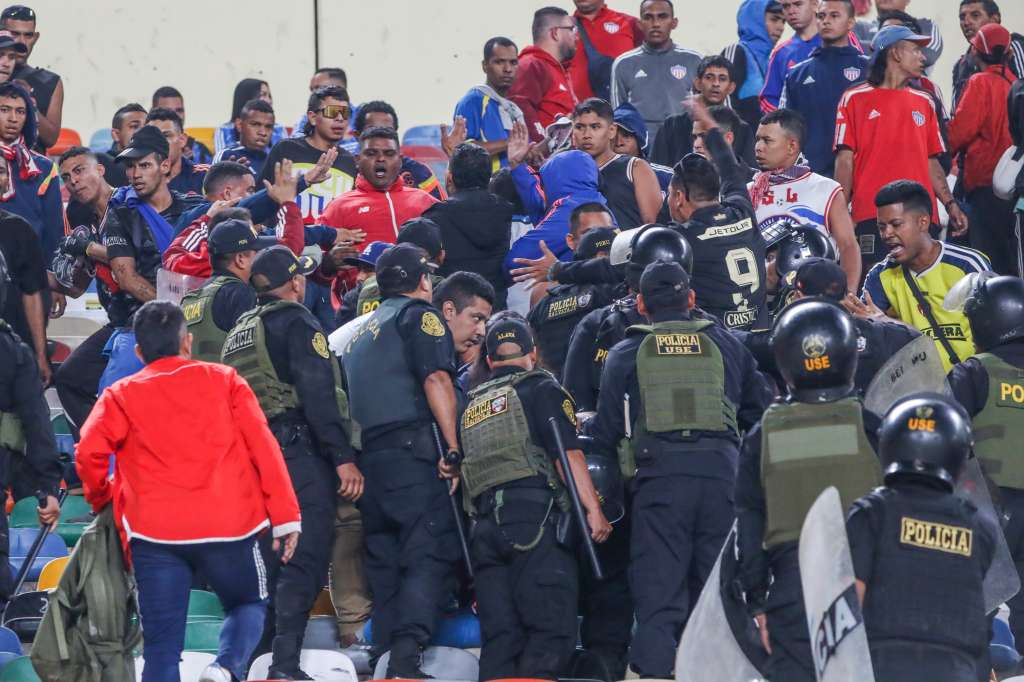 AMDEP1138. LIMA (PERÚ), 07/05/2024.- Hinchas de Junior se enfrentan con integrantes de la Policía de Perú este martes, en un partido de la fase de grupos de la Copa Libertadores entre Universitario y Junior en el estadio Monumental U Marathon, en Lima (Perú). EFE/ Aldair Mejía