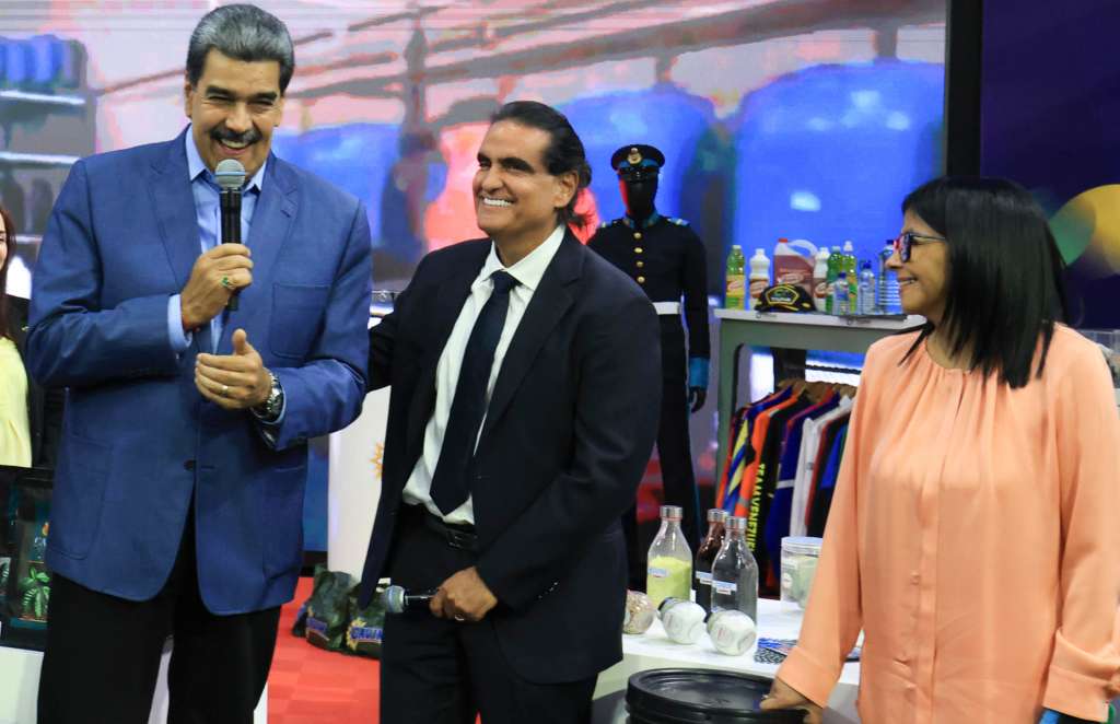 AME136. CARACAS (VENEZUELA), 23/12/2025.- Fotografía cedida por el Palacio de Miraflores del presidente de Venezuela, Nicolás Maduro (i) acompañado del ministro de Industrias y Producción Nacional, Alex Saab (c) y la vicepresidenta ejecutiva, Delcy Rodruguez, durante un acto de gobierno en Caracas (Venezuela). "Pienso que el presidente Trump lo pudiera hacer mejor en su país y en el mundo. Le iría mejor, ¿verdad? Dentro de su país con los temas económicos, sociales, le iría mejor con el mundo si él atendiera los temas de su país. Cada presidente en lo suyo", dijo Maduro en un acto con productores en Caracas, transmitido por el canal estatal Venezolana de Televisión (VTV). EFE/ Palacio De Miraflores /SOLO USO EDITORIAL/ NO VENTAS/ SOLO DISPONIBLE PARA ILUSTRAR LA NOTICIA QUE ACOMPAÑA (CRÉDITO OBLIGATORIO)