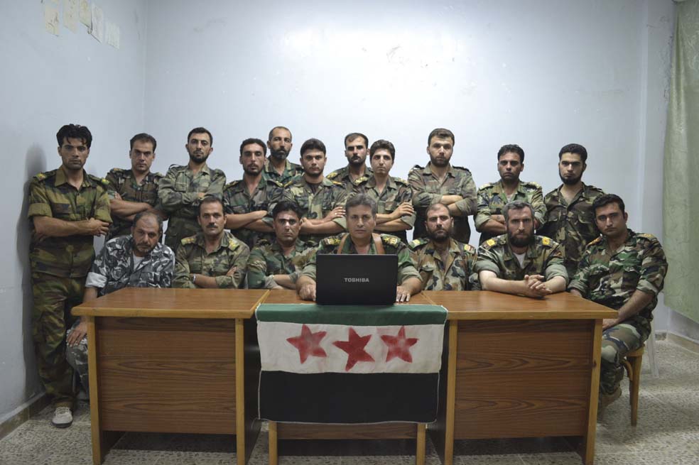 Un grupo de rebeldes sirios posa detrás de un computador. Ellos también son blanco del SEA. / Reuters