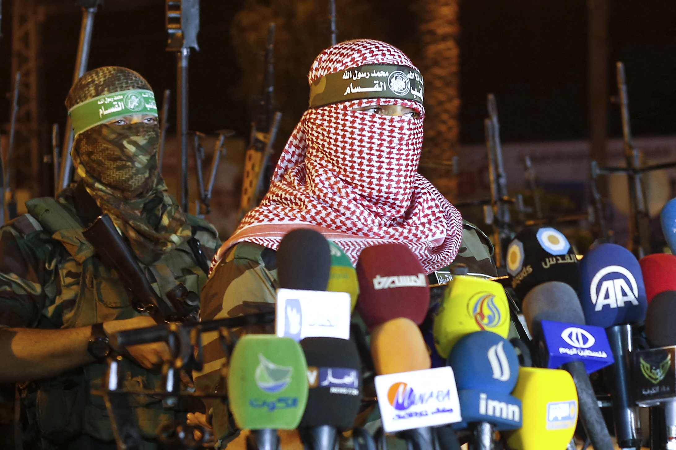 (FILES) Abu Obeida (R), spokesman for the armed wing of Hamas, the Ezzedine al-Qassam Brigades, delivers a statement in Gaza City late on July 8, 2015. Israeli Prime Minister Benjamin Netanyahu said on August 31 that Israel had carried out a strike on Abu Obeida. (Photo by Mohammed ABED / AFP)