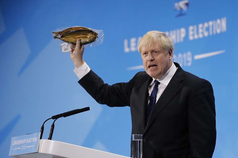 (FILES) In this file photo taken on July 17, 2019 Conservative MP and leadership contender Boris Johnson holds up kipper fish in plastic packaging as he speaks at the final Conservative Party leadership election hustings in London, on July 17, 2019.
Almost in the same breath, Boris Johnson supporters hail his optimistic vision for Britain, while reassuring the listener that he will have a team to take care of the details. The ex-London mayor has wooed Tories with a promise to get Britain out of the European Union and if elected party leader, he will take over as prime minister on July 24. But critics are alarmed at how Johnson seems to struggle with the finer points of Brexit, and question his attention to detail in previous jobs.
/ AFP / Tolga AKMEN / TO GO WITH AFP STORY BY ALICE RITCHIE