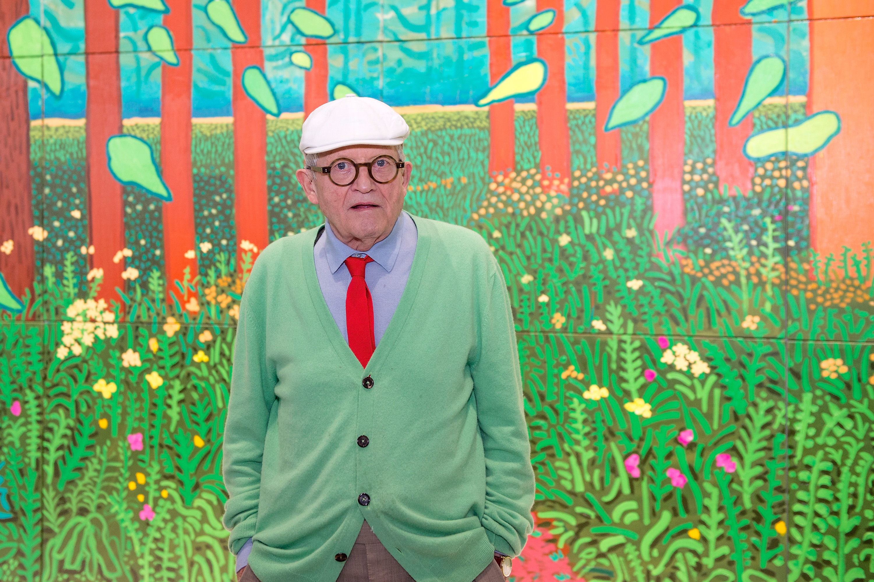 PARIS, FRANCE - SEPTEMBER 26: David Hockney poses in front of his painting "The Arrival Of Spring in Woldgate, East Yorkshire in 2011" which he offered to the museum at Centre Pompidou on September 26, 2017 in Paris, France. (Photo by Aurelien Meunier/Getty Images)