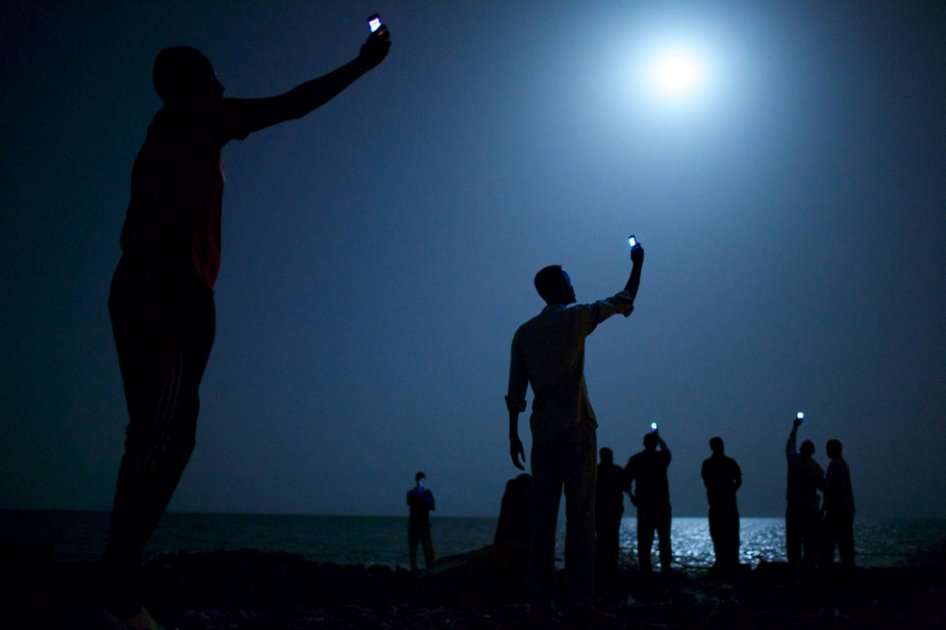 "Señal", la fotografía que plasma a un grupo de inmigrantes africanos en Yibuti a la orilla del mar levantando sus teléfonos móviles para capturar una red telefónica de bajo coste de la vecina Somalia.