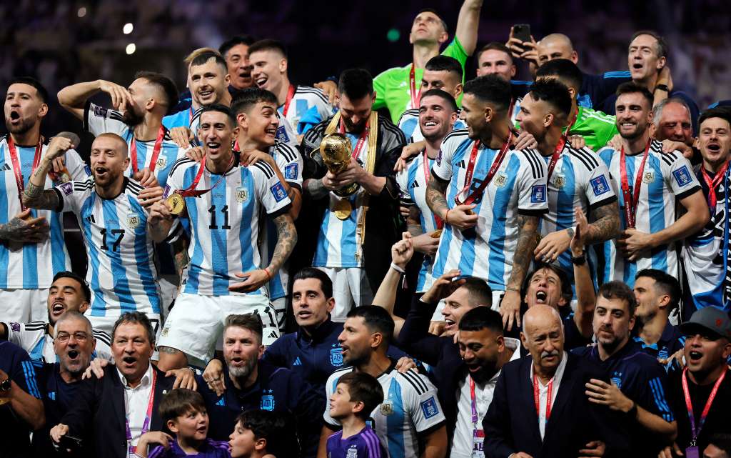 Lusail (Qatar), 18/12/2022.- Lionel Messi (C) of Argentina looks at the trophy as his teammates celebrate after winning the FIFA World Cup 2022 Final between Argentina and France at Lusail stadium, Lusail, Qatar, 18 December 2022. Argentina won 4-2 on penalties. (Mundial de Fútbol, Francia, Estados Unidos, Catar) EFE/EPA/Ronald Wittek