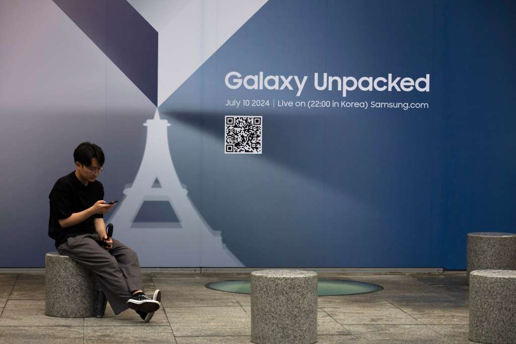 Seoul (Korea, Republic Of), 08/07/2024.- A man sits next the signage outside of the Gangnam store of Samsung Electronics in Seoul, South Korea, 08 July 2024. The National Samsung Electronics Union (NSEU) launched a three-day walkout over better pay conditions from 08 to 10 July. (Corea del Sur, Seúl) EFE/EPA/JEON HEON-KYUN