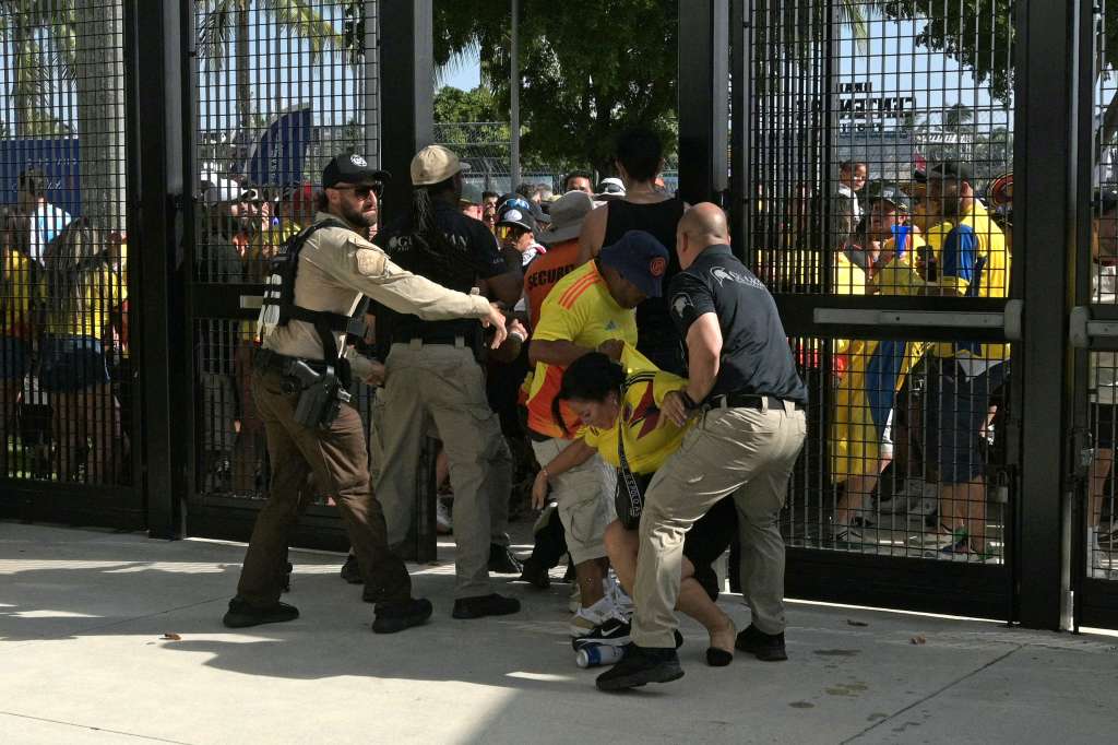 La policía de Estados Unidos contiene a varios hinchas en la entrada del estadio en Miami.