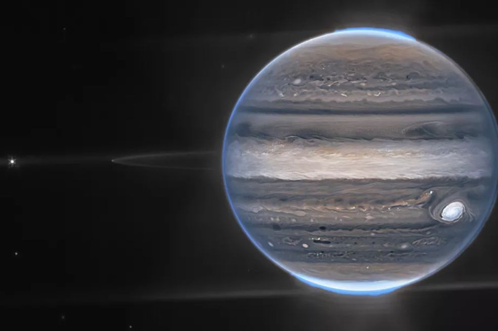 La Cámara de Infrarrojo Cercano (NIRCam) del Webb captó una
imagen compuesta de Júpiter. Se pueden ver las auroras que rodean sus polos y débiles anillos que circundan al gigante gaseoso. También se ven dos de las 79 lunas de Júpiter: Amaltea es el punto brillante en el extremo izquierdo, mientras que Adrastea es el punto tenue en el borde de los anillos, entre Amaltea y Júpiter.