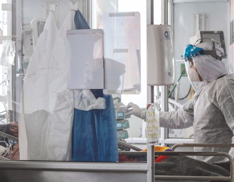 TOPSHOT - Health personnel wearing a protective suits against the spread of the COVID-19 assist a patient at the intensive care unit in El Tunal Public Hospital, Bogota, on June 16, 2020.
Bogota's Mayor, Claudia Lopez, declared on Sunday the orange alert in the capital of Colombia, due to the occupation of 54% of the intensive care units (ICU) amid the new coronavirus pandemic. / AFP / Juan BARRETO