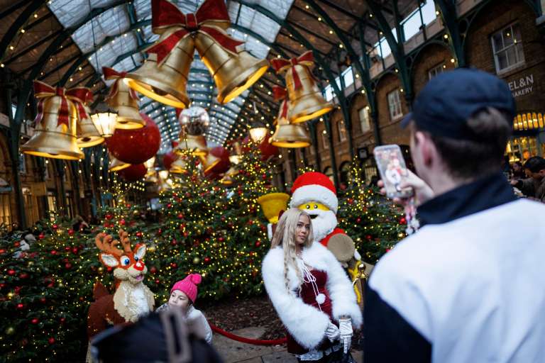 LONDON (United Kingdom), 22/12/2025.- A person wearing a Christmas themed outfit poses for a picture at Covent Garden Market as people do their Christmas shopping amid festive decorations in London, Britain, 22 December 2025. (Reino Unido, Londres) EFE/EPA/TOLGA AKMEN