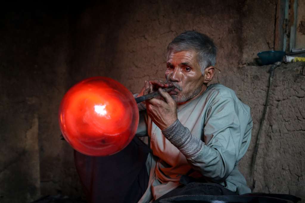 In this photograph taken on August 11, 2024, Ghulam Sakhi Saifi, an Afghan glassblower, crafts a glassware at his traditional workshop in Afghanistan's western city of Herat.