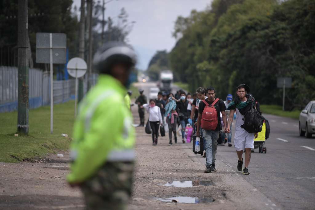 Migrantes venezolanos transitan por la autopista norte de Bogotá de regreso a Venezuela, en medio de la cuarentena obligatoria por cuenta del Covid-19.