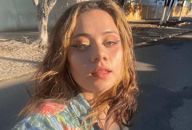 Mujer rubia mira a la pantalla mientras entrecierra los ojos.