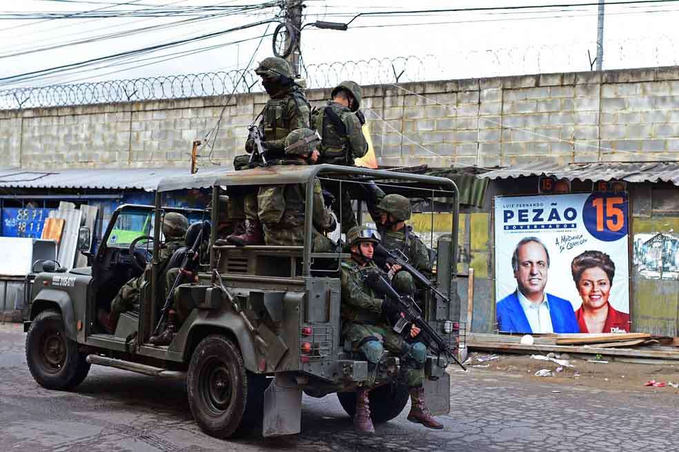 Una patrulla militar vigila una calle de la favela Mare, en Río de Janeiro. Brasil elegirá presidente, gobernadores y diputados este domingo. / AFP