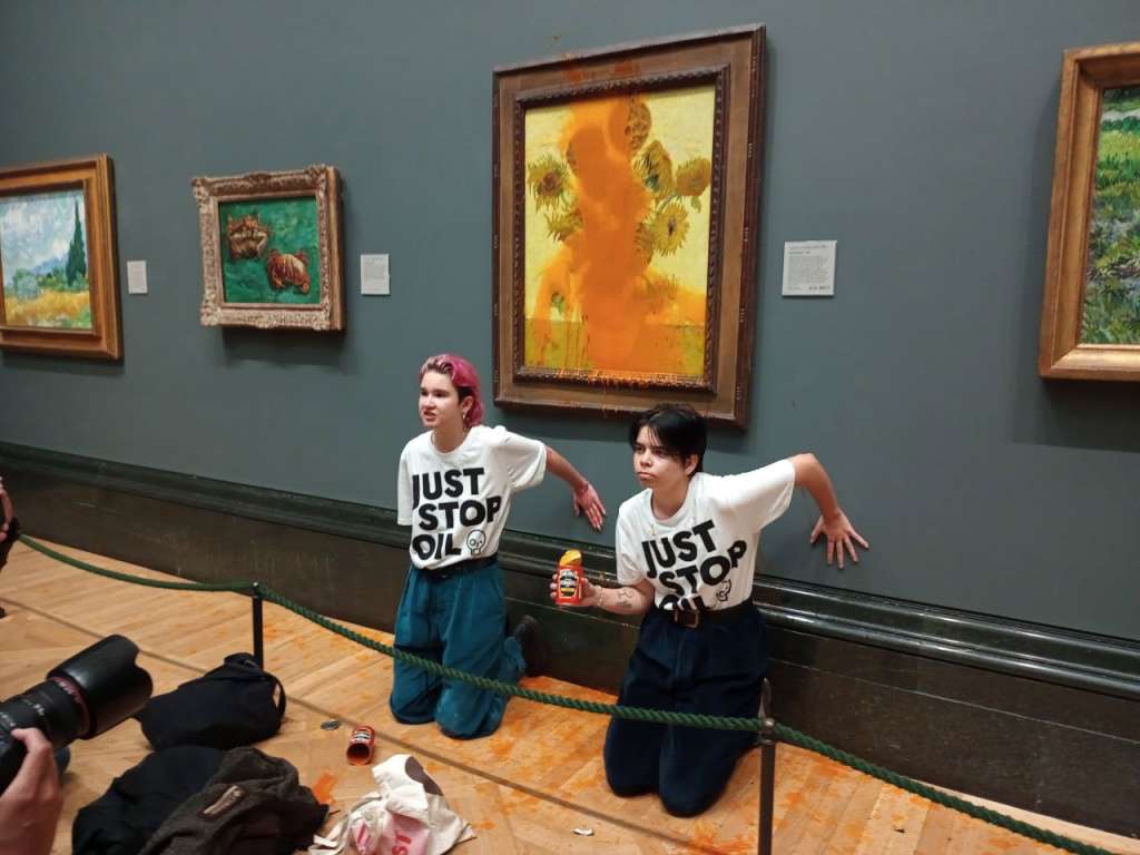 London (United Kingdom), 14/10/2022.- A handout photo made available by the 'Just Stop Oil' climate activism group of two protesters who threw Heinz Tomato soup at Vincent Van Gogh's 1888 painting 'Sunflowers' at the National Gallery in London, 14 October 2022. The protesters then knelt down in front of the painting and appeared to glue their hands to the wall beneath it before being arrested. (Protestas, Reino Unido, Londres) EFE/EPA/JUST STOP OIL HANDOUT MANDATORY CREDIT HANDOUT EDITORIAL USE ONLY/NO SALES